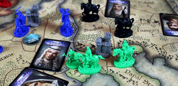 Knights of various player colors, a castle, and some character cards populate the map of Europe game board